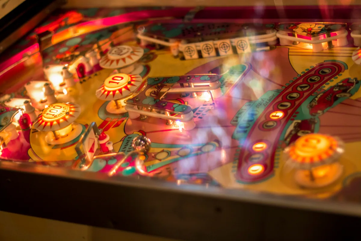 Playfield lights bloom through the glass in pink, gold and teal.