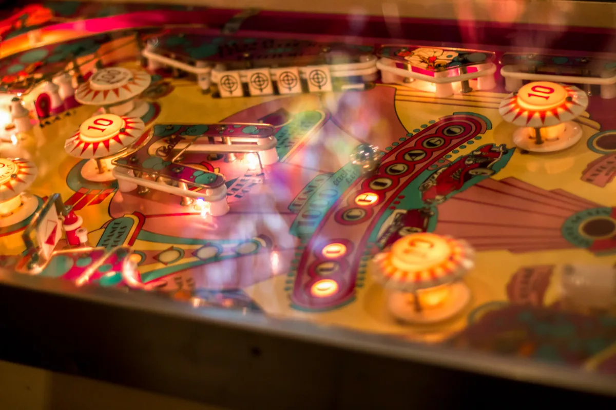 A playfield seen close, its targets and bumpers lit from within.