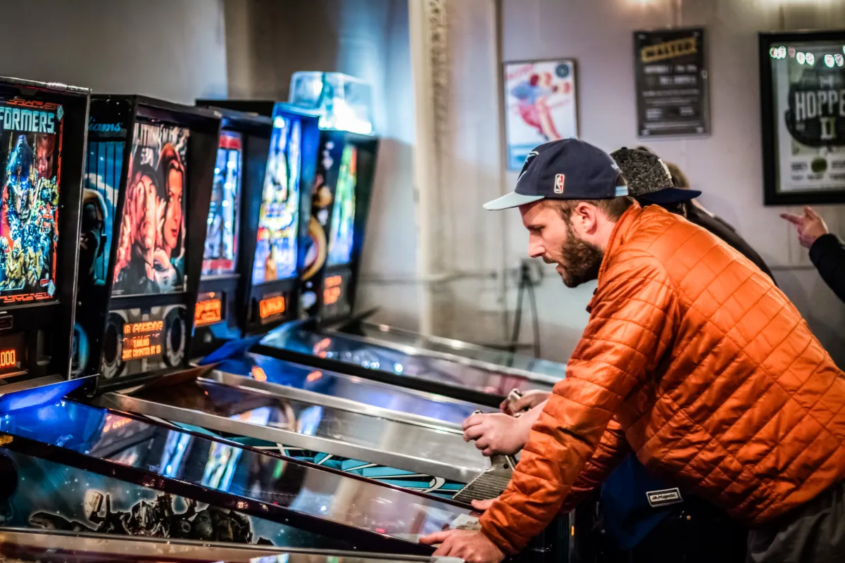 A player leans into a shot as others watch from further down the row.