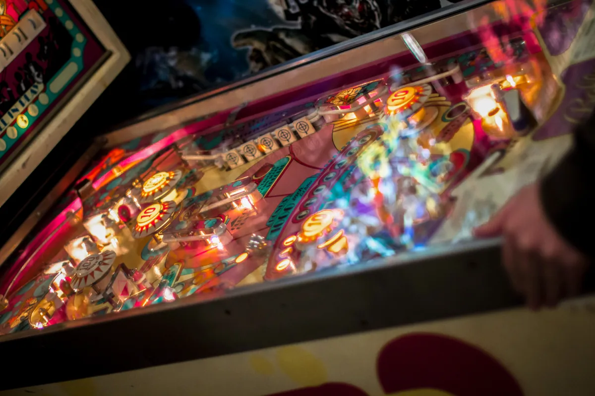 A machine seen from a low angle, its lit playfield running away toward the backglass.