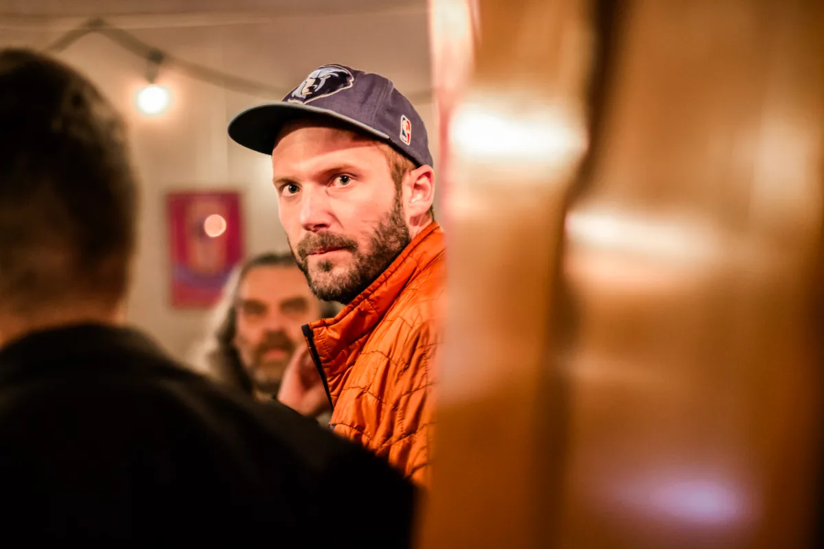 A player glances up, framed between two out-of-focus figures in the crowd.