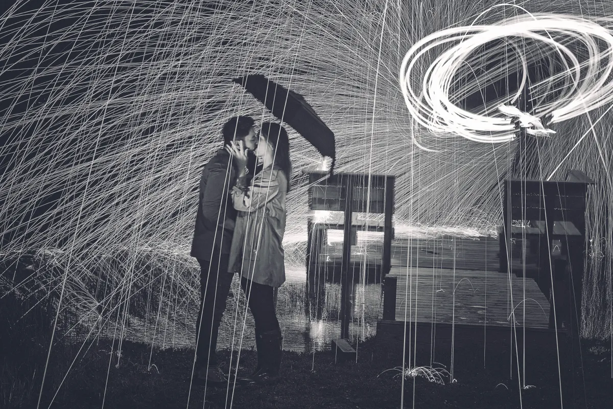 Sparks from spinning steel wool arcing around a figure at night