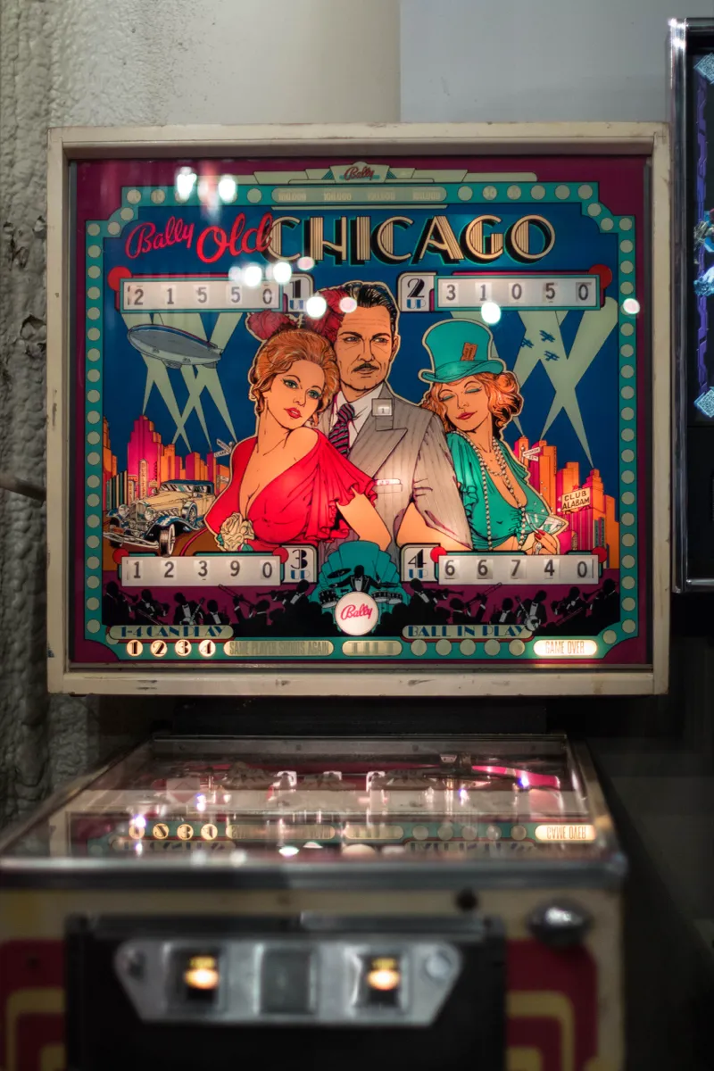 A vintage Old Chicago pinball machine lit up at an event venue